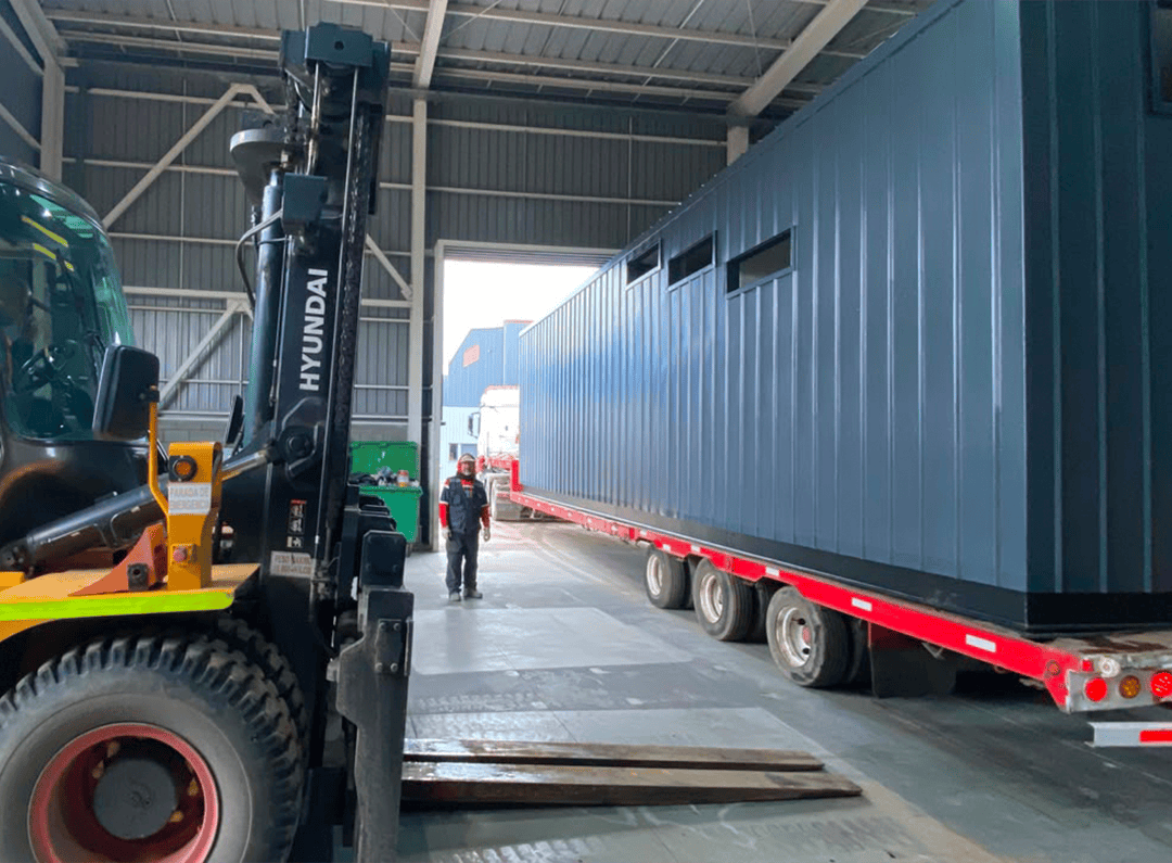 Despacho de infraestructura modular técnica. Carga de sala eléctrica a medida en camión de transporte desde fábrica REMAC.