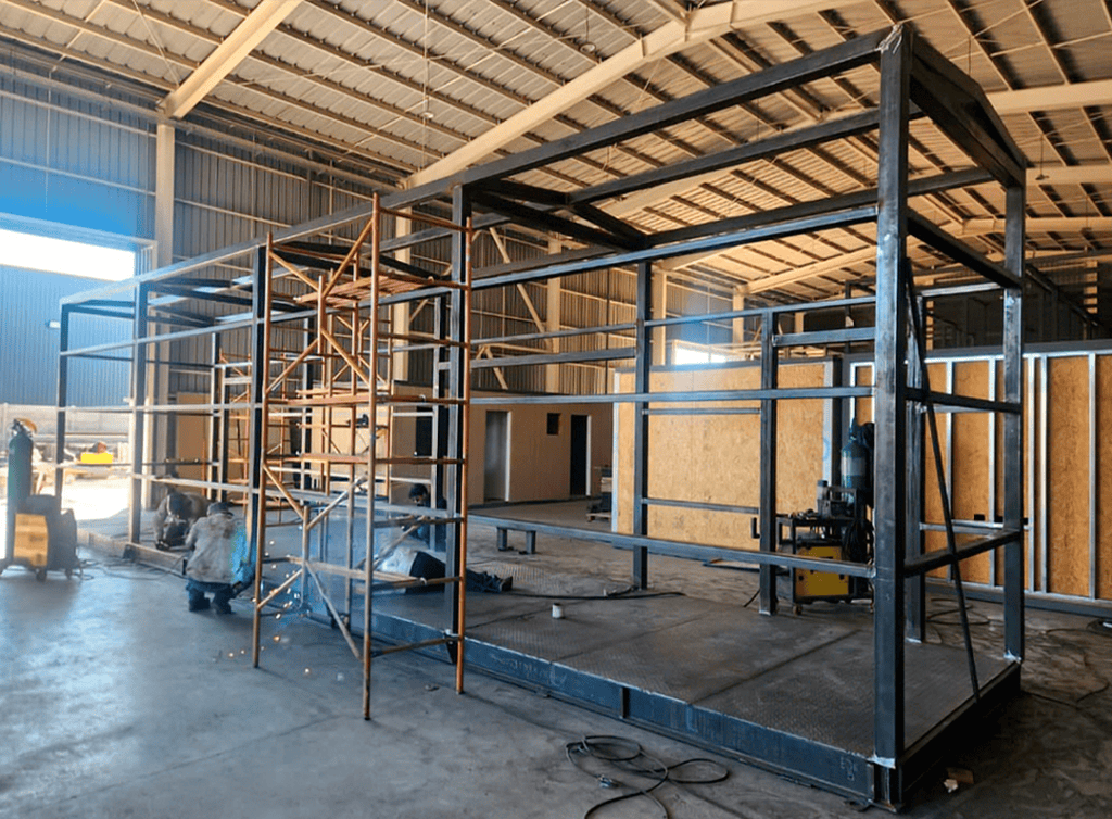 Construcción de estructura de acero para infraestructura modular técnica. Ensamblaje de esqueleto metálico a medida para sala eléctrica o Data Center en fábrica REMAC.